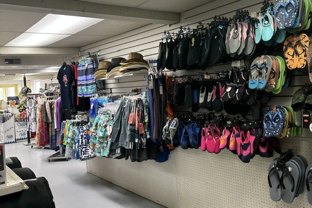 Wall of water shoes, flip flops and sandals next to beach apparel at Bayview